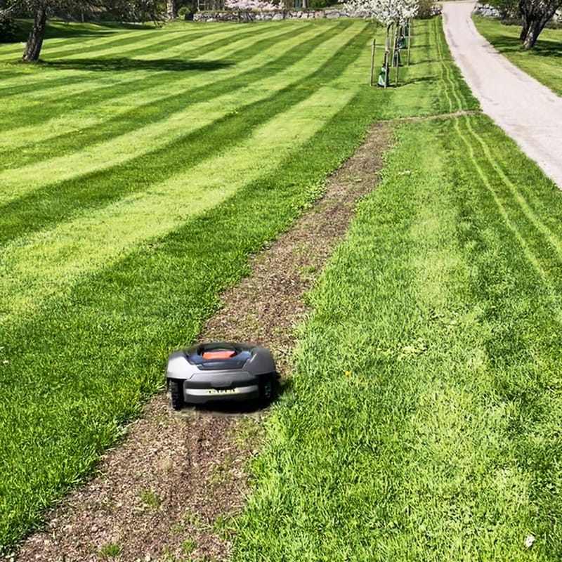 Nyinstallerad robotgräsklippare i drift på gräsmattan